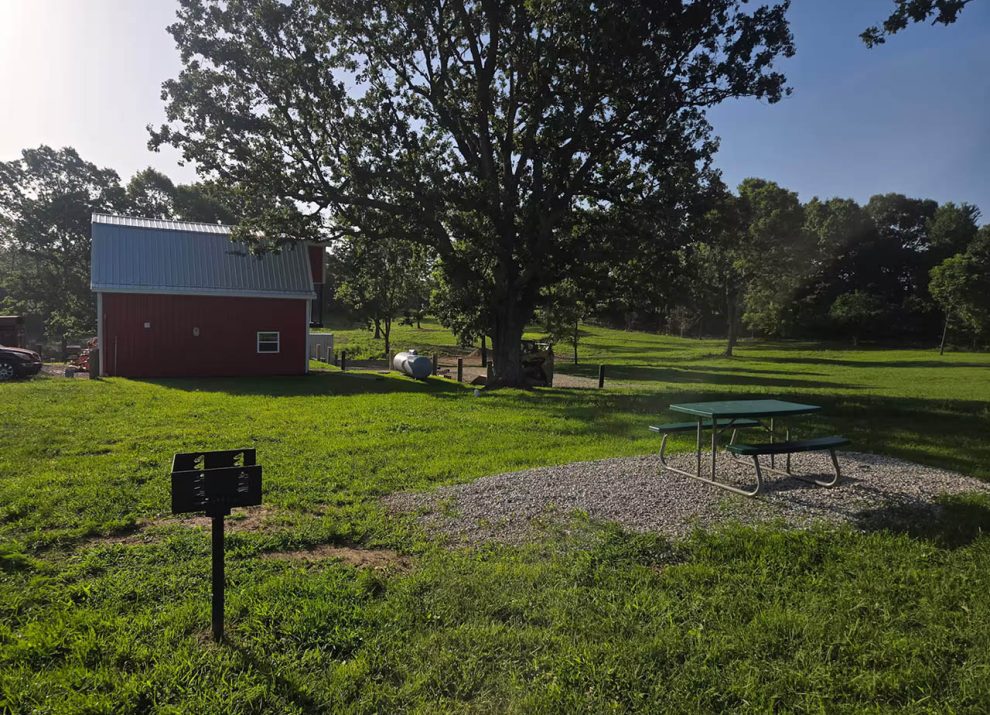 Private picnic table and charcoal grill beside Kozy Kamper rental at 4 Seasons RV Park