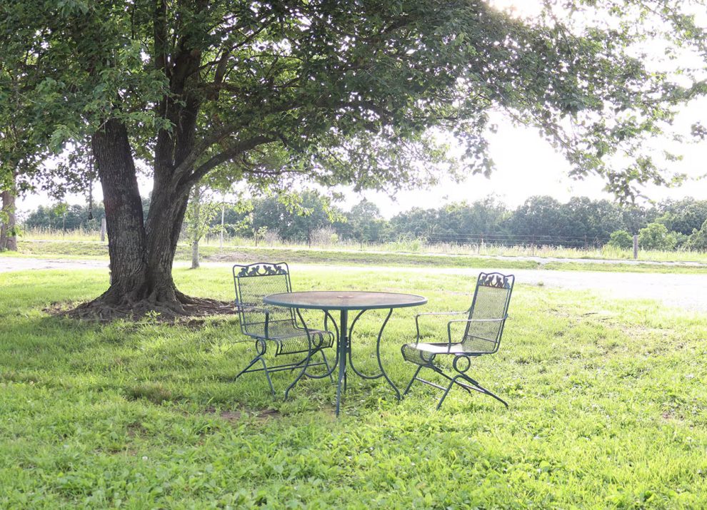 Outdoor patio seating beside Nelly's Nook vacation rental at 4 Seasons RV Park in Mansfield, Missouri