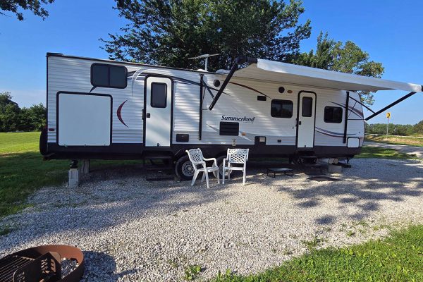Vacation Rental Camper | 4 Seasons RV Park - Mansfield, Missouri Fully furnished vacation rental camper at 4 Seasons RV Park in Mansfield, Missouri with outdoor seating, an awning, and a private fire ring.